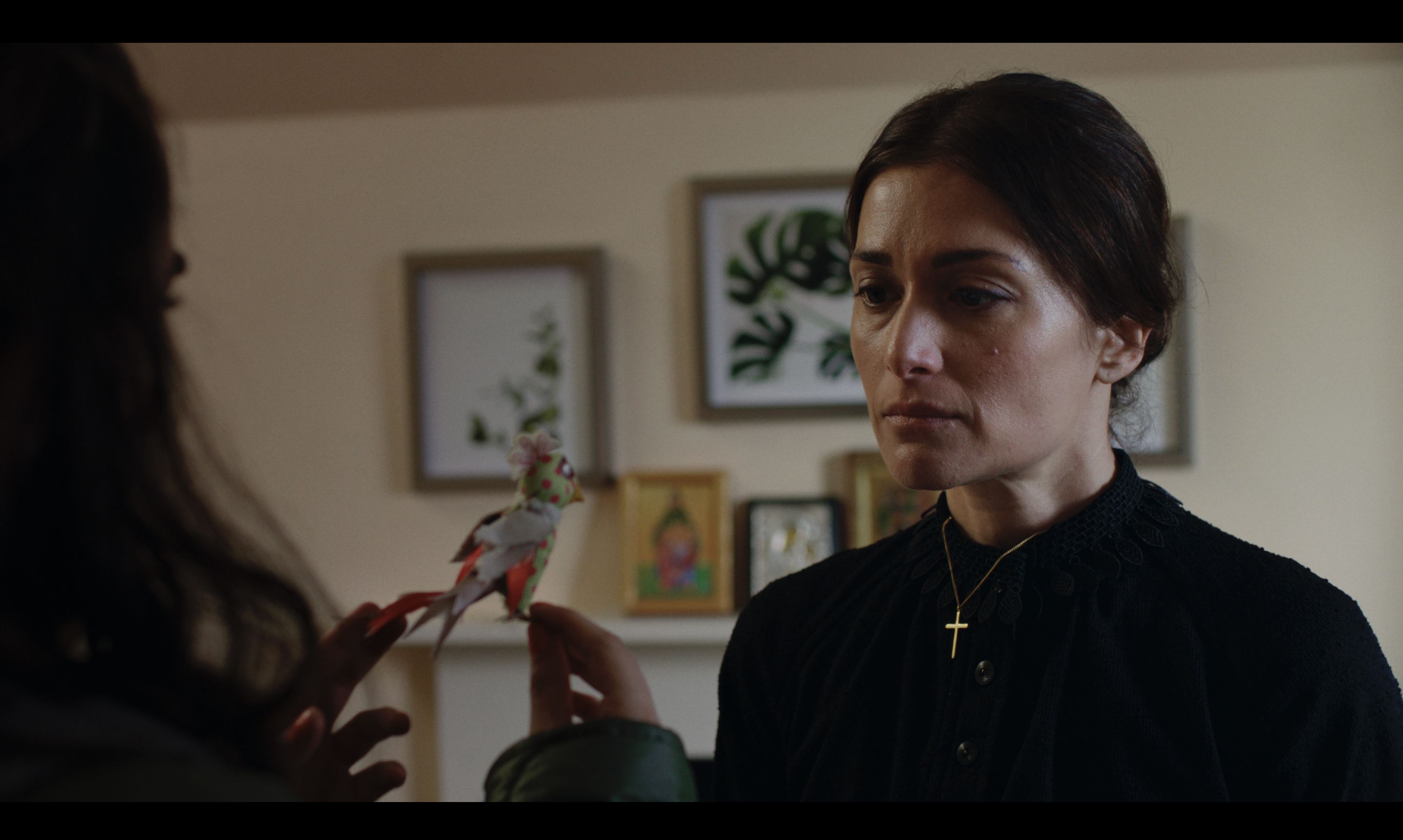 Mother observes handmade bird.